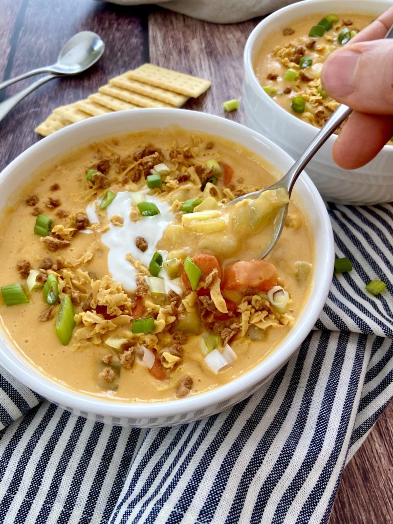 taking a bite of vegan potato soup